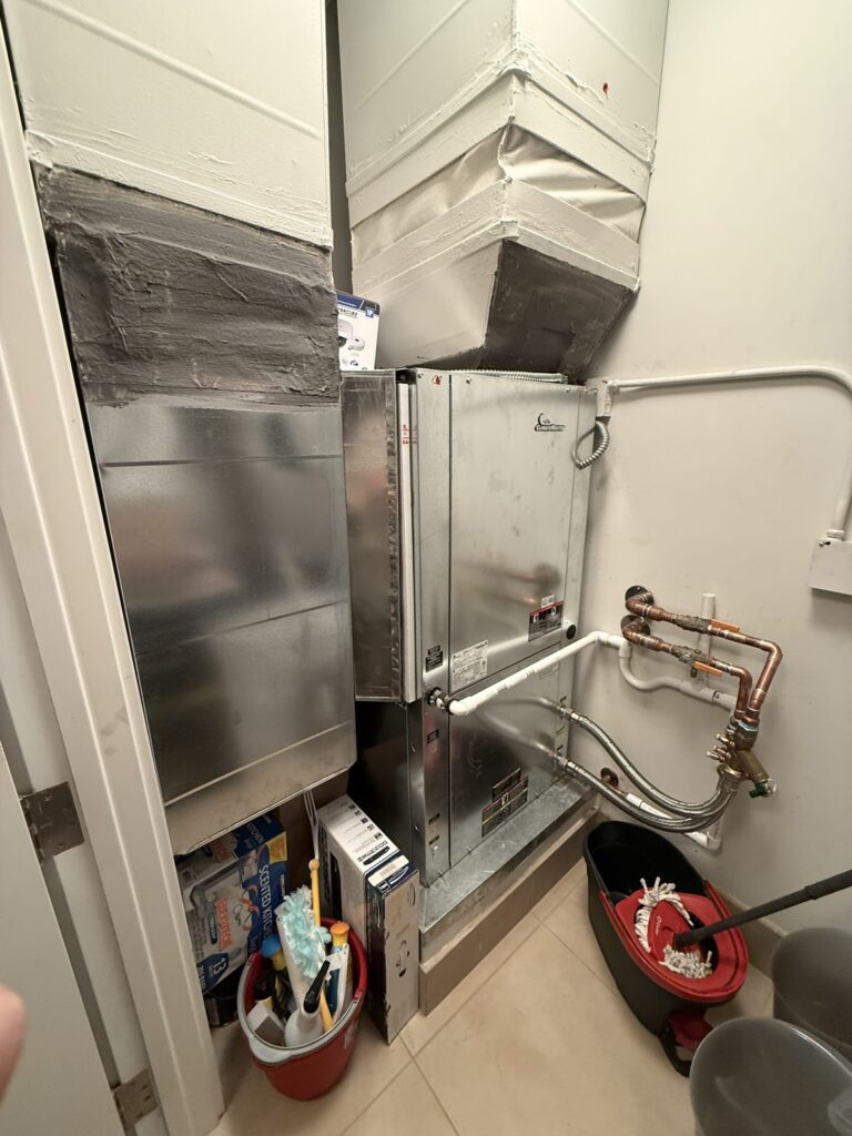 A newly installed Climatemaster water source heat pump unit and associated ductwork in a utility closet.