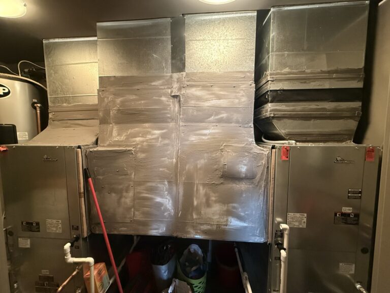 Two new ClimateMaster water source heat pumps connected to sealed metal ductwork in an interior utility space.