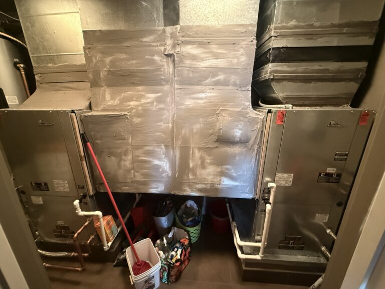 Two newly installed ClimateMaster water-source heat pump units connected to ductwork in an interior utility space.