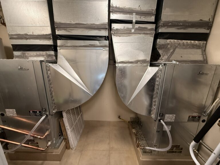 Two new ClimateMaster water source heat pump units with connected ductwork, copper piping, and drain lines.